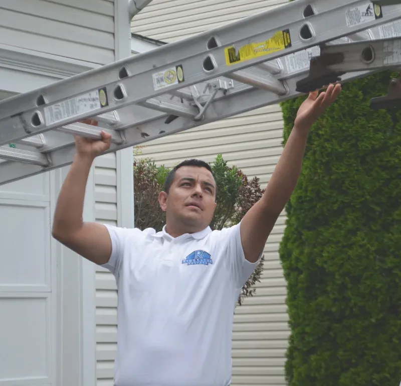 A Ridgeline Roofers technician setting a ladder for a roof inspection